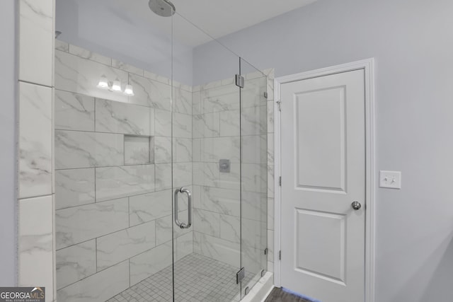 bathroom featuring a shower with shower door