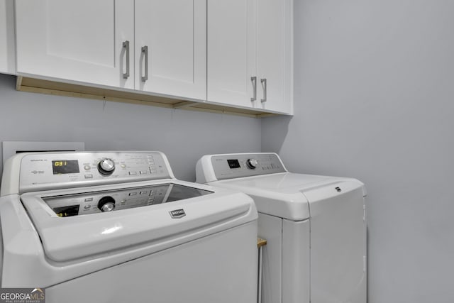 laundry room featuring independent washer and dryer and cabinets