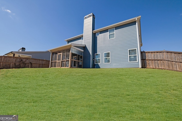 back of property with a lawn and a sunroom