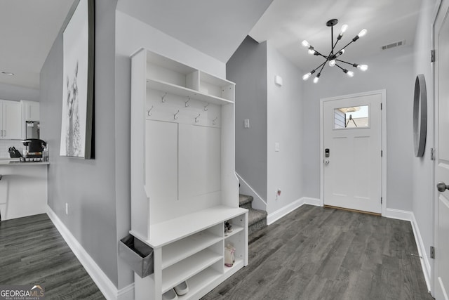 mudroom with dark wood-type flooring and a chandelier