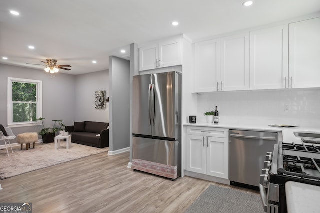 kitchen featuring white cabinetry, decorative backsplash, stainless steel appliances, and light hardwood / wood-style flooring