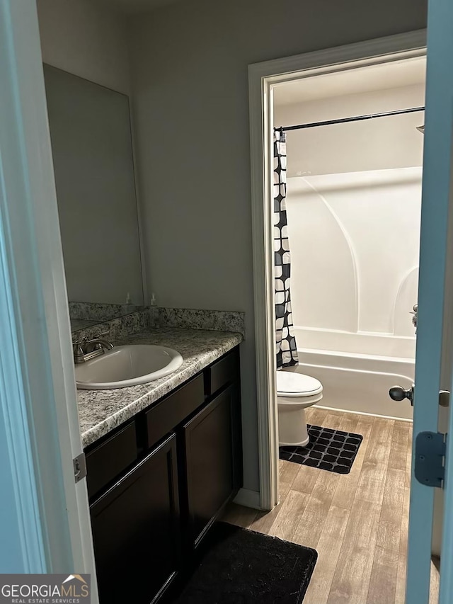 full bathroom featuring vanity, wood finished floors, toilet, and shower / tub combo with curtain