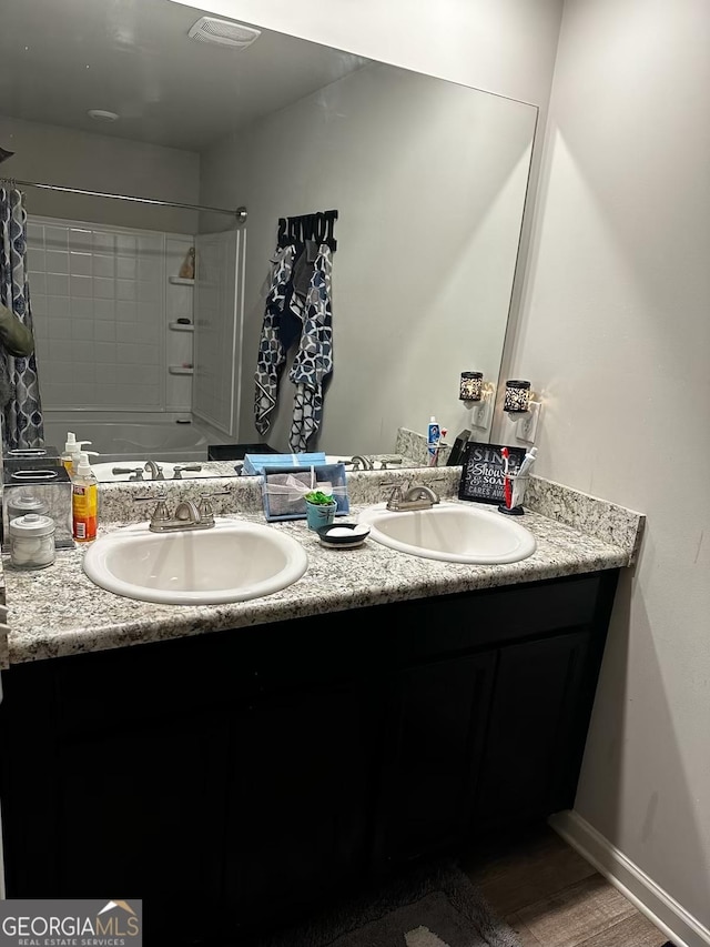 bathroom with visible vents, a sink, baseboards, and double vanity