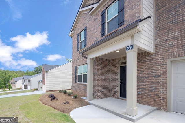 property entrance with a garage and brick siding