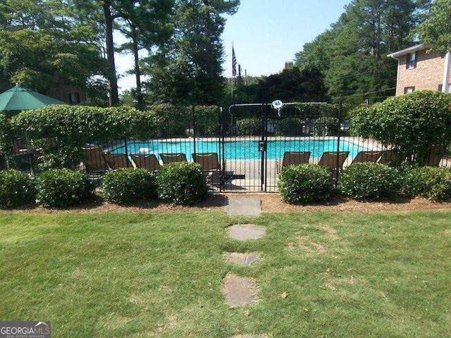 view of swimming pool featuring a yard