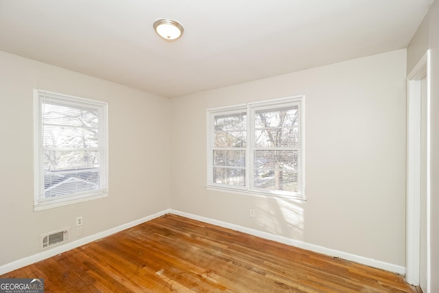 empty room with wood-type flooring and plenty of natural light