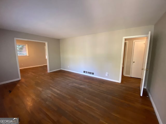 spare room with dark wood-type flooring