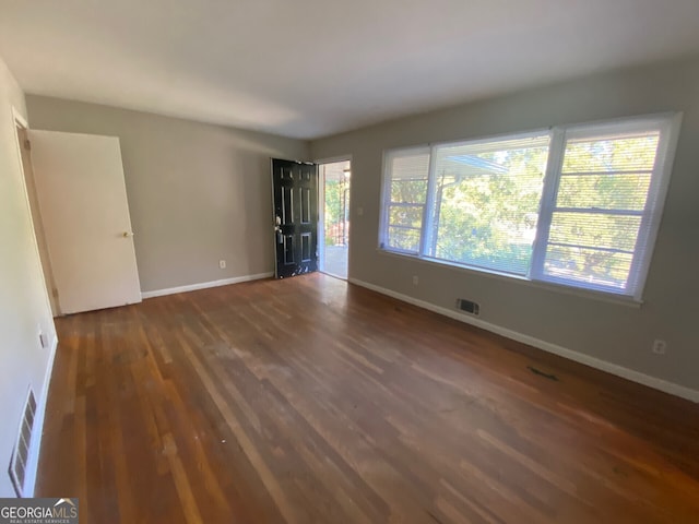 spare room with dark hardwood / wood-style floors and a wealth of natural light