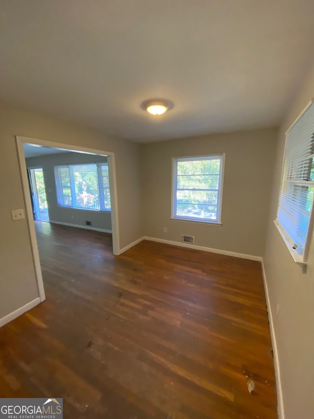 spare room with dark wood-type flooring