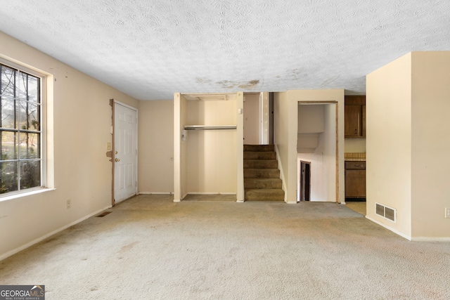 unfurnished bedroom featuring light carpet and a textured ceiling