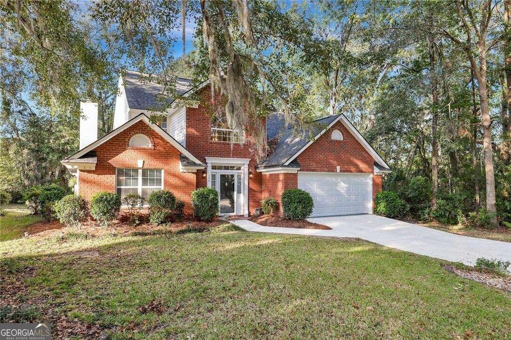 front facade with a front yard and a garage