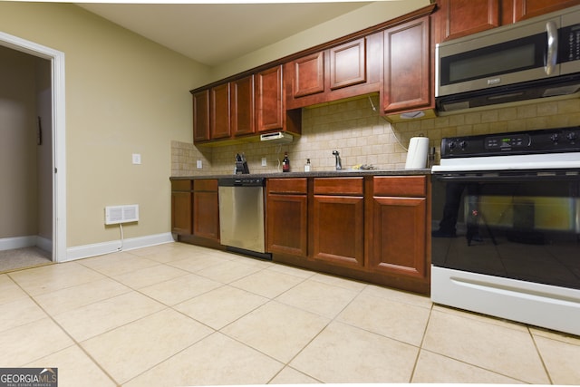 kitchen with decorative backsplash, sink, light tile patterned floors, and appliances with stainless steel finishes