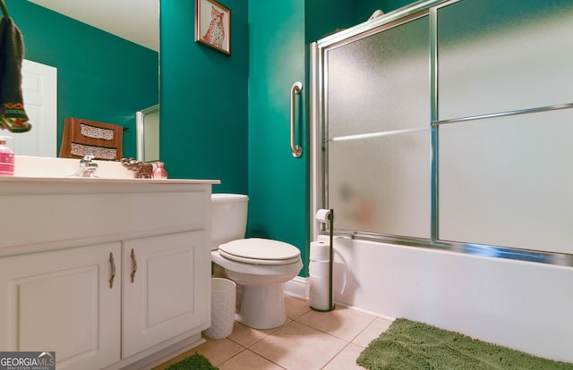 full bathroom featuring tile patterned floors, vanity, enclosed tub / shower combo, and toilet