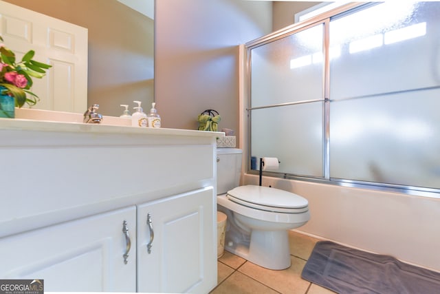 full bathroom featuring toilet, vanity, tile patterned floors, and enclosed tub / shower combo