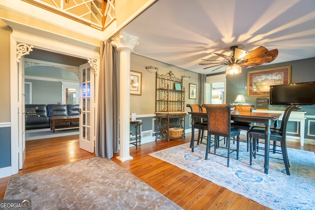 dining area featuring ceiling fan, ornate columns, and hardwood / wood-style floors