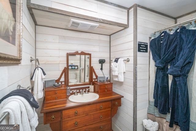 bathroom featuring vanity, walk in shower, and wooden walls