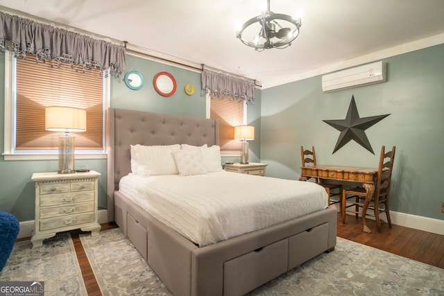 bedroom featuring a wall unit AC, hardwood / wood-style flooring, and an inviting chandelier