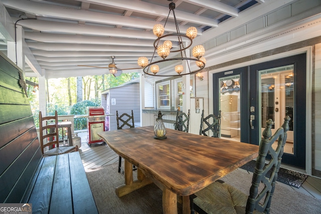 dining room featuring french doors, a healthy amount of sunlight, wood-type flooring, and an inviting chandelier