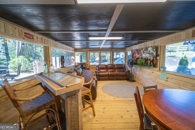 dining room with wood walls and hardwood / wood-style floors