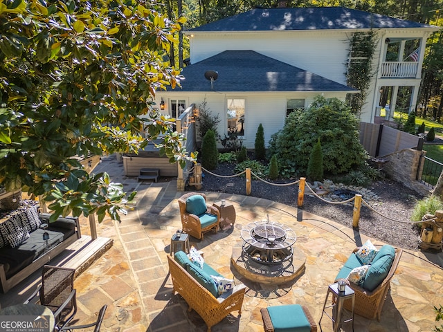 view of patio featuring a hot tub and an outdoor living space with a fire pit