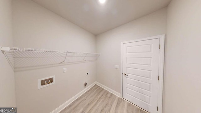 clothes washing area featuring light hardwood / wood-style floors, hookup for a washing machine, and electric dryer hookup