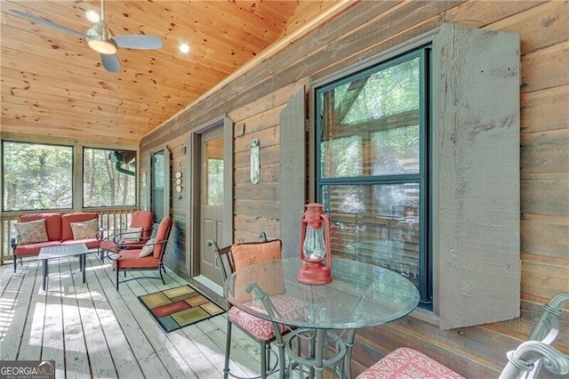 sunroom / solarium featuring wood ceiling, vaulted ceiling, ceiling fan, and plenty of natural light