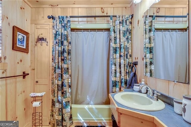 bathroom featuring vanity, wooden walls, and shower / tub combo with curtain