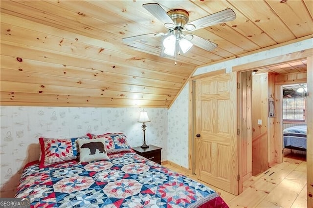 bedroom with wood ceiling, lofted ceiling, wooden walls, and ceiling fan