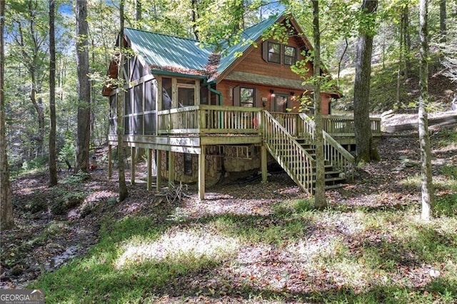 rear view of house featuring a deck and a sunroom