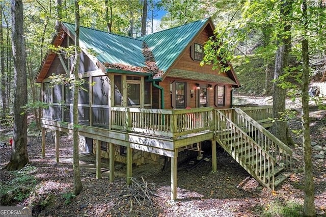 exterior space featuring a wooden deck and a sunroom