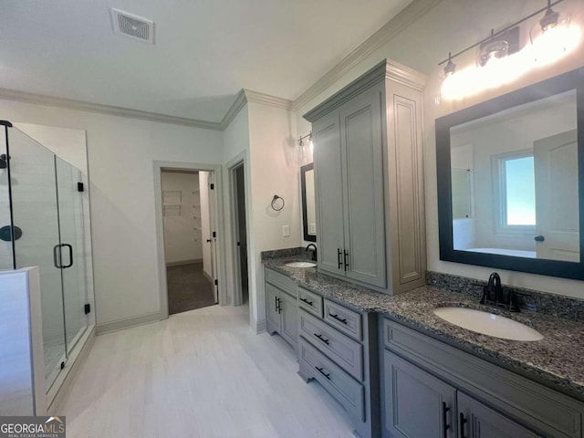 bathroom featuring vanity, crown molding, an enclosed shower, and hardwood / wood-style floors