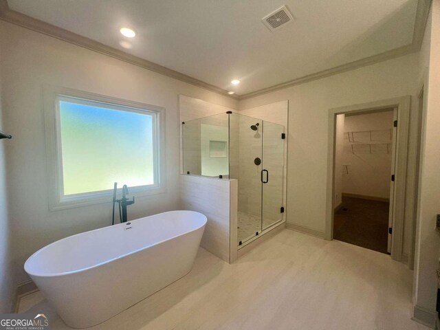 bathroom featuring crown molding and shower with separate bathtub