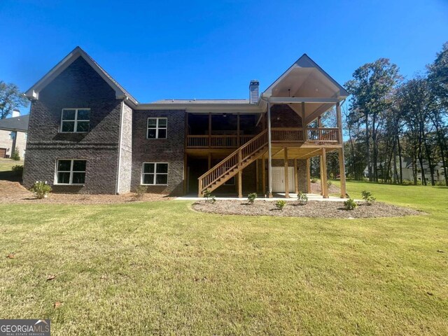 rear view of property with a deck and a lawn