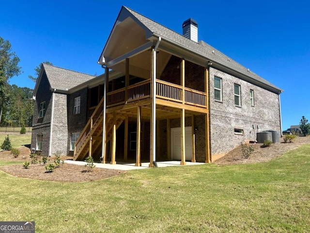 rear view of property with a patio, central AC, and a lawn