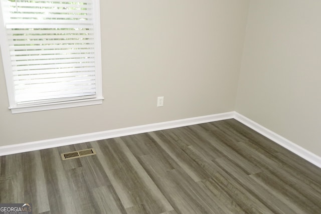 unfurnished room with dark hardwood / wood-style flooring