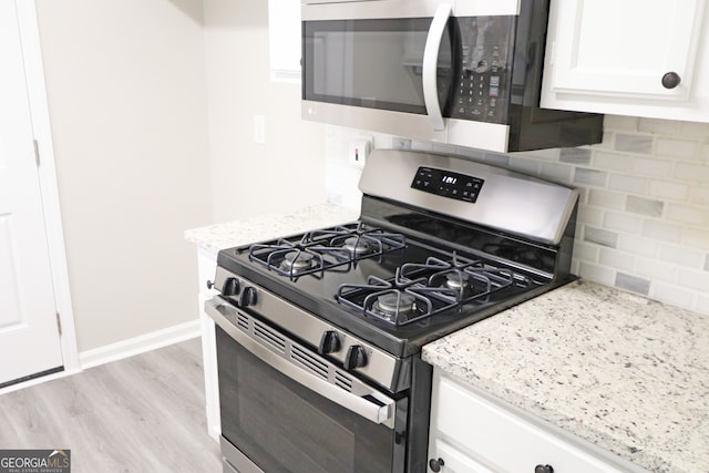 kitchen featuring light hardwood / wood-style flooring, white cabinetry, stainless steel appliances, and backsplash