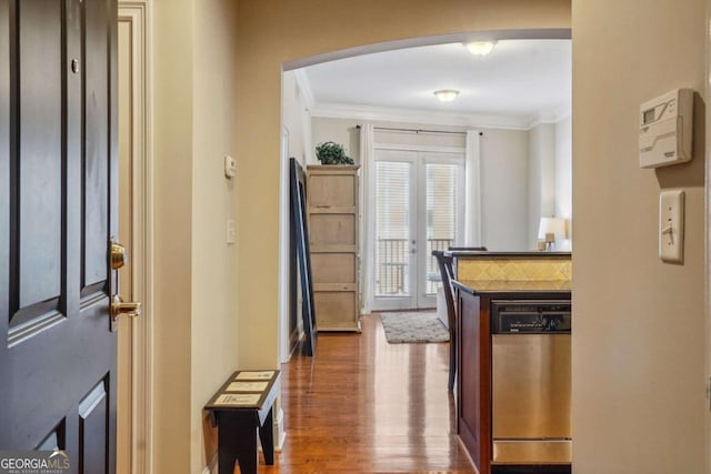 corridor with ornamental molding, french doors, and wood finished floors