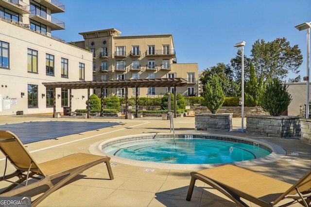 view of swimming pool featuring a pergola, a patio area, and a hot tub