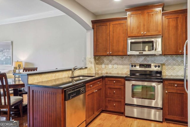 kitchen featuring light hardwood / wood-style flooring, kitchen peninsula, stainless steel appliances, and sink