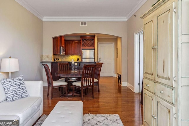 dining area featuring dark wood-type flooring and ornamental molding