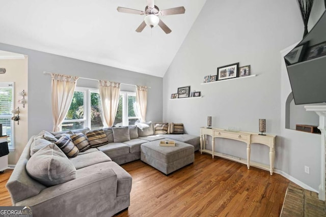 living room with wood-type flooring, high vaulted ceiling, and ceiling fan