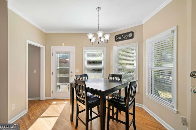 dining area with light hardwood / wood-style floors, a healthy amount of sunlight, and ornamental molding