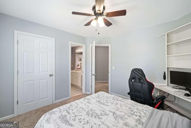 carpeted bedroom with ensuite bathroom and ceiling fan