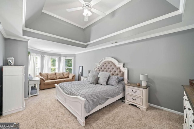 bedroom featuring light colored carpet, a tray ceiling, and ceiling fan