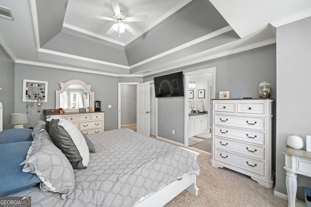 carpeted bedroom featuring connected bathroom, a raised ceiling, ornamental molding, and ceiling fan