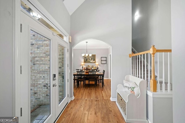 hall with light hardwood / wood-style floors and lofted ceiling