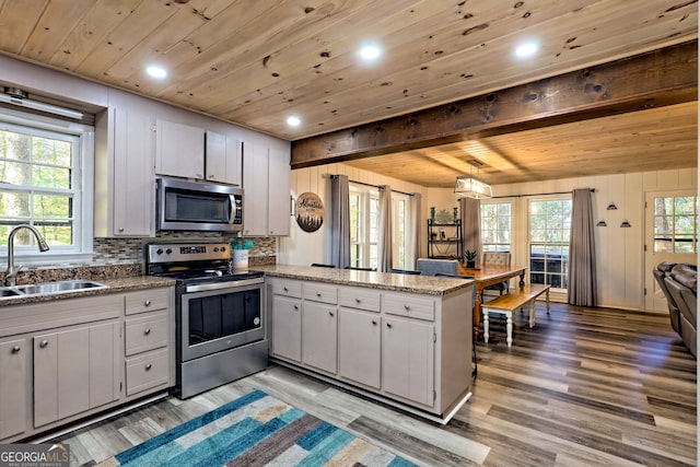 kitchen featuring sink, kitchen peninsula, light hardwood / wood-style floors, stainless steel appliances, and wooden ceiling