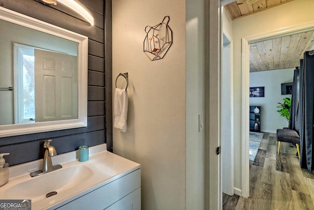 bathroom featuring vanity, wood-type flooring, and wooden ceiling