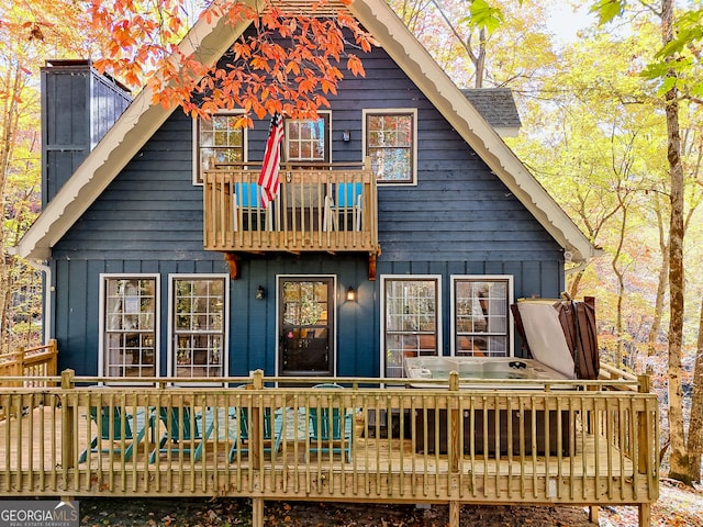 back of house with a balcony and a wooden deck