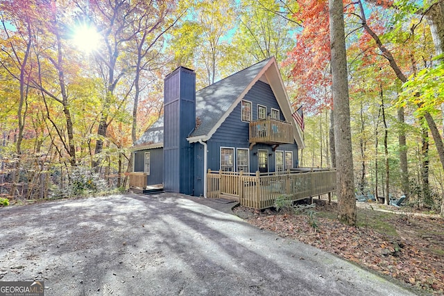 exterior space with a wooden deck and a balcony